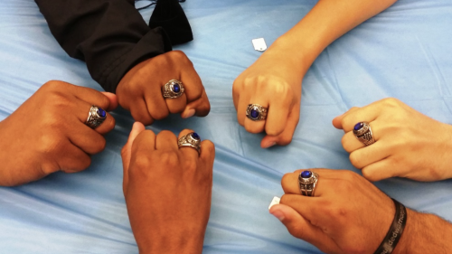 Students of color showing hands together