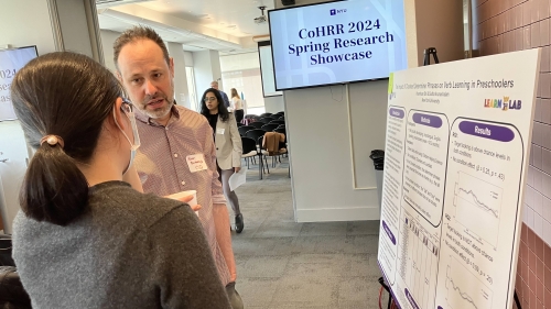 Adam Buchwald speaks with a woman at a poster