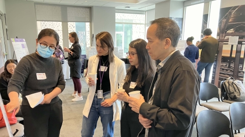 Huanhuan Shi presents a poster to a small group