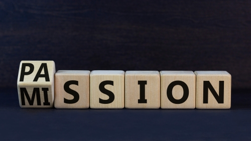 Do your mission with passion. Turned wooden cubes and changed the concept word Mission to Passion. Beautiful black background. Business motivational passion and mission concept