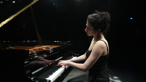 Solo pianist performing under spotlights