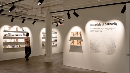 view of the exhibition space with postcards lining the far wall.