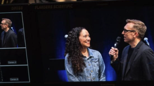 Professor interviewing student with a microphone