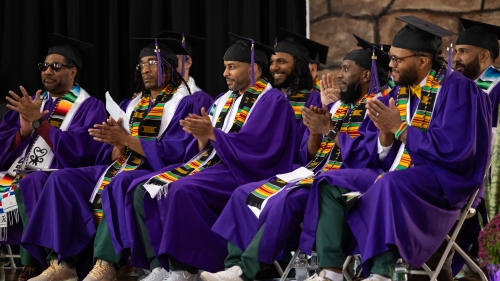 A large group of graduates applauds