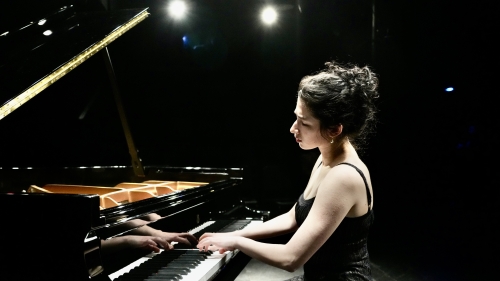Piano student CiCi Fader playing a grand piano