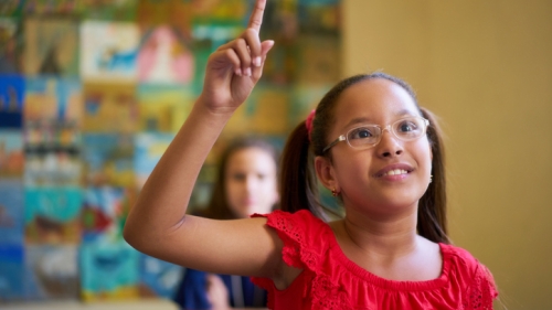 Child raising her hand in class
