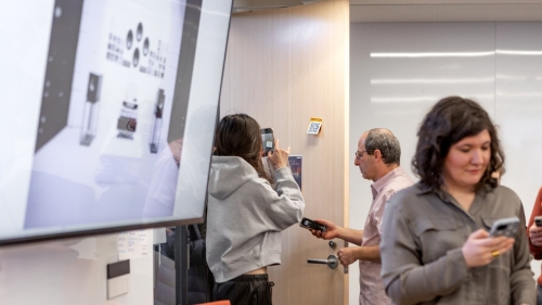A student stands in front of a door scanning a QR code for the museum