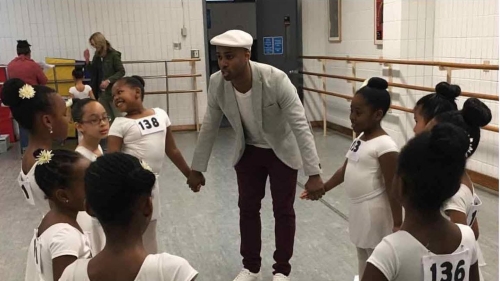 Young ballet dancers and Leyland Simmons hold hands in a circle