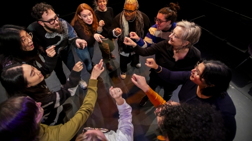 Drama Therapy students and faculty sitting in tight circle