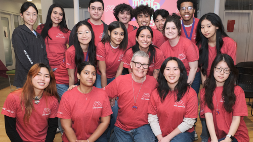 A large group of people in red t-shirts poses for the photo