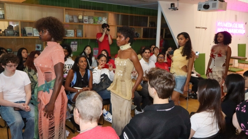 Four models stand amidst a crowd