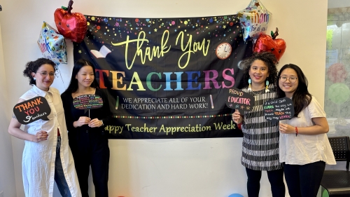 Four people stand around a sign that says, Thank You Teachers