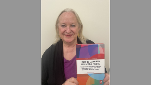 Nancy Smithner holds her book, Embodied Learning in Educational Theatre