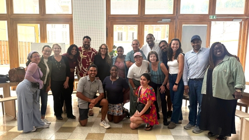 A group of NYC teachers poses in front of a wall of windows
