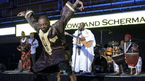 Dance Ed graduate performing on stage jumping mid air