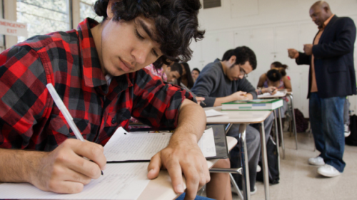 A student writes at a desk
