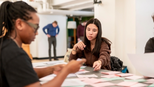 Students sitting at table studying index cards as a group