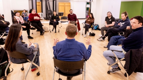 Instructors and students sitting in circle talking