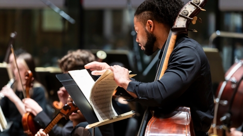Strings students organizing music during performance