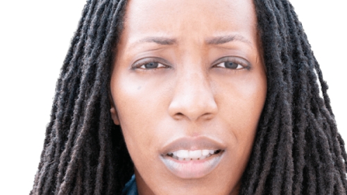 Image captures a headshot of Dr. Bettina L. Love. The phoot captures the NYU Metro Center 2026 Keyunote Speakers against a white backgroun with shoulder length locks. Dr. Love whears a blue collareded denim shirt with a red sportcoat.
