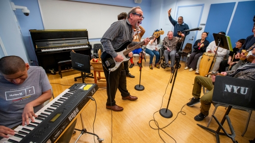 Alan Turry plays instruments with a crowd of people.
