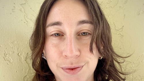 Amanda smiles in a selfie photo, she has brown shoulder length hair and wears a silver chain necklace.