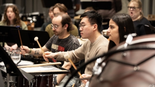 Students play percussion instruments.