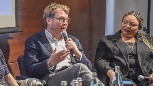 Two panelists sit and talk