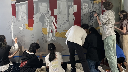 Students painting a mural in a hallway