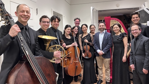 Musicians hold their instruments and pose for the photo