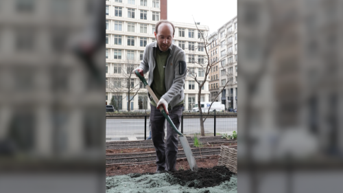 A photo of Professor Jonathan Lambert, outdoors, shoveling dirt