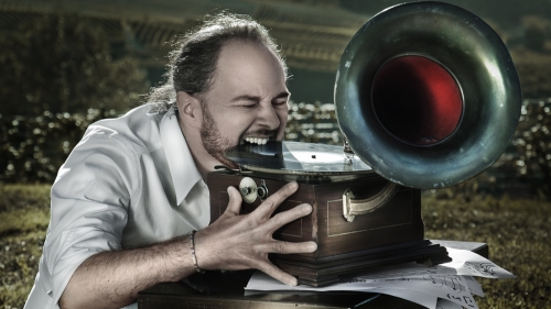 Man biting an album on an old phonograph