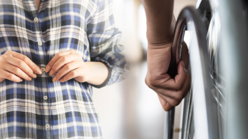 Person in a wheelchair and someone buttoning their shirt
