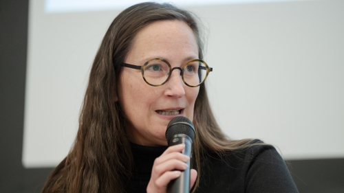 Dr. Raphaela Henze speaking into microphone