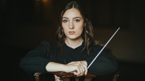 Piano Studies alumna Georgia Mills posing with conductors baton