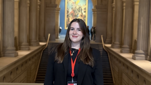 A white woman with brown hair smiles from inside the Metropolitan Museum of Art.