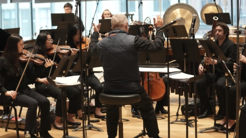 Chamber group practicing and being led by conductor