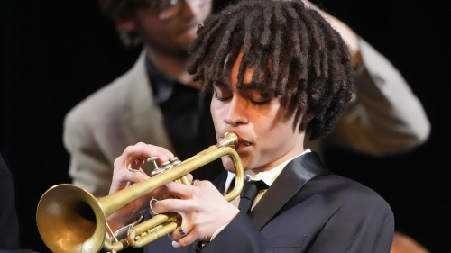 Close up of trumpet player performing with bass player behind him