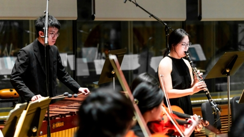 Students performing with clarinet player being featured standing up