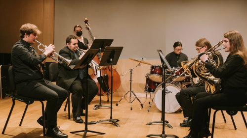 Group of students practicing brass, bass and drums in studio