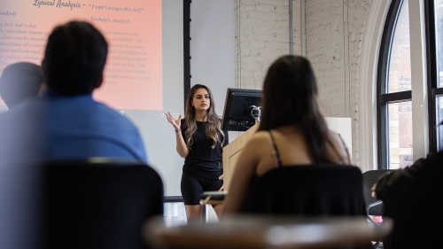 A student presents at the front of the class