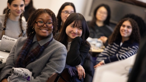 Students sit and smile during a talk