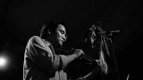 A black and white photo of Sam Wu playing the violin