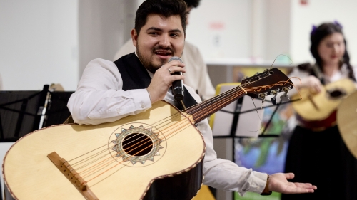 Mariachi singer holding large guitar and microphone