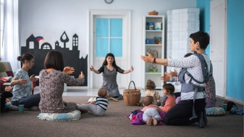Moms and babies sit in a circle
