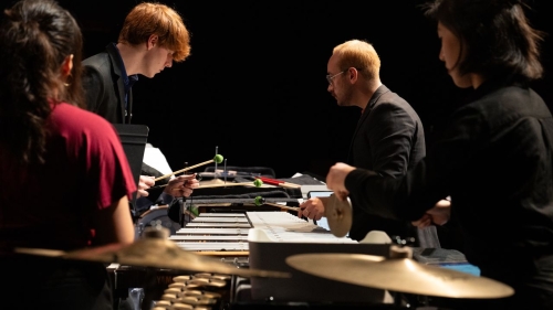 Four percussion players playing a group of instruments