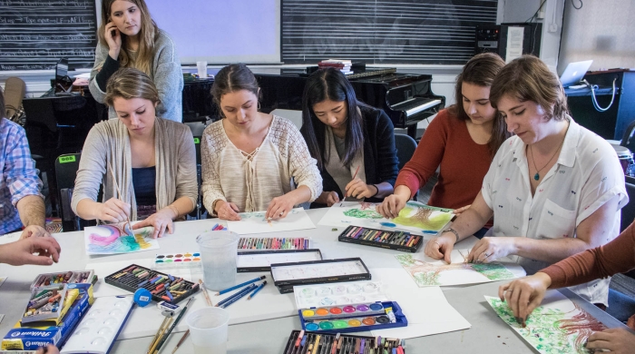 Students working on art projects around table