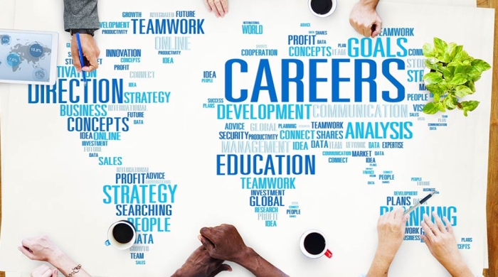 professionals collaborating at table covered with a world map made of business and education keywords 