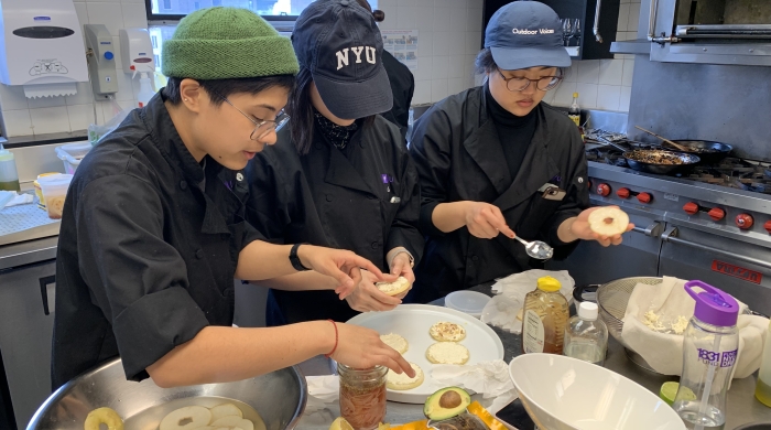 Three students working together to create an asian pear dish.