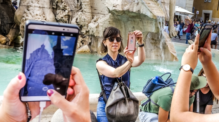 multiple tourists taking smart phone pictures
